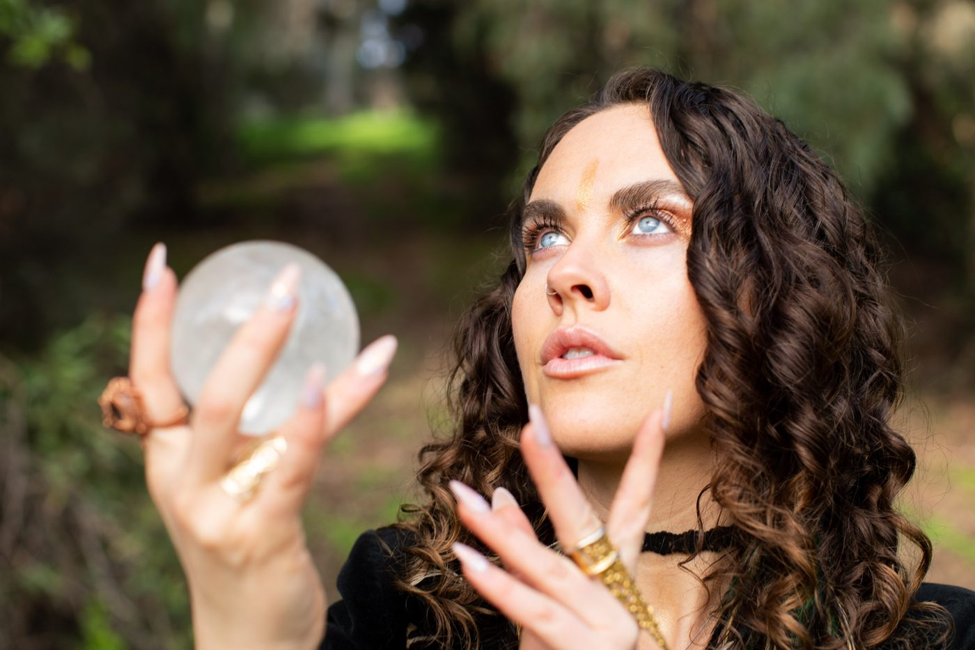 Damiana holding a crystal ball up to the light